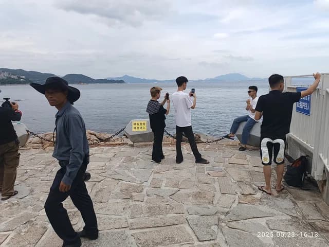Visitors walking beside the water at Dameisha Seaside Beach Park in Shenzhen