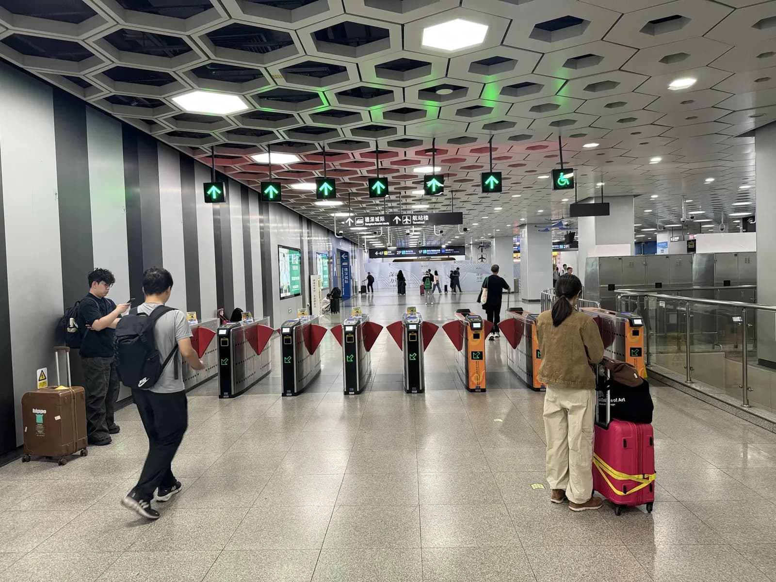 Travelers with suitcases at the ticket gates of Airport Station on Shenzhen Metro