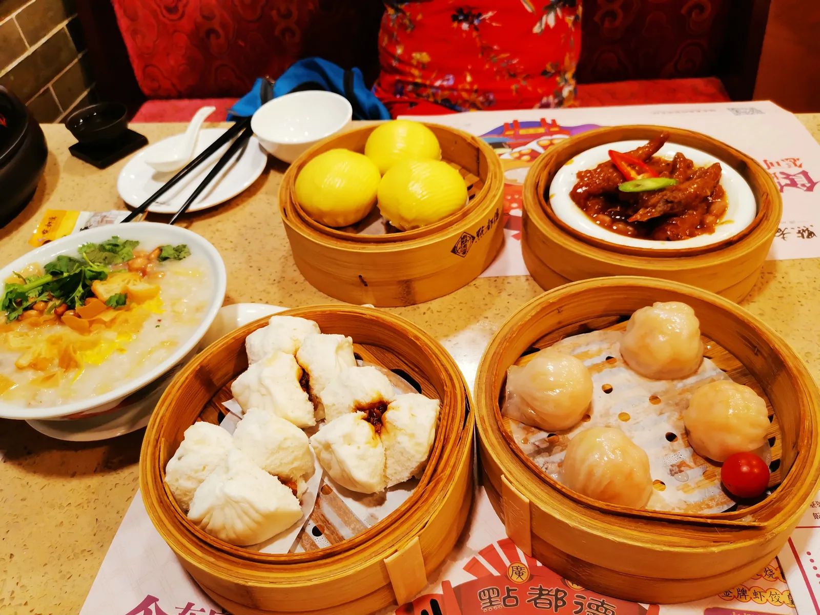 Morning tea spread of steamed buns, har gow, congee and braised dishes in bamboo steamers
