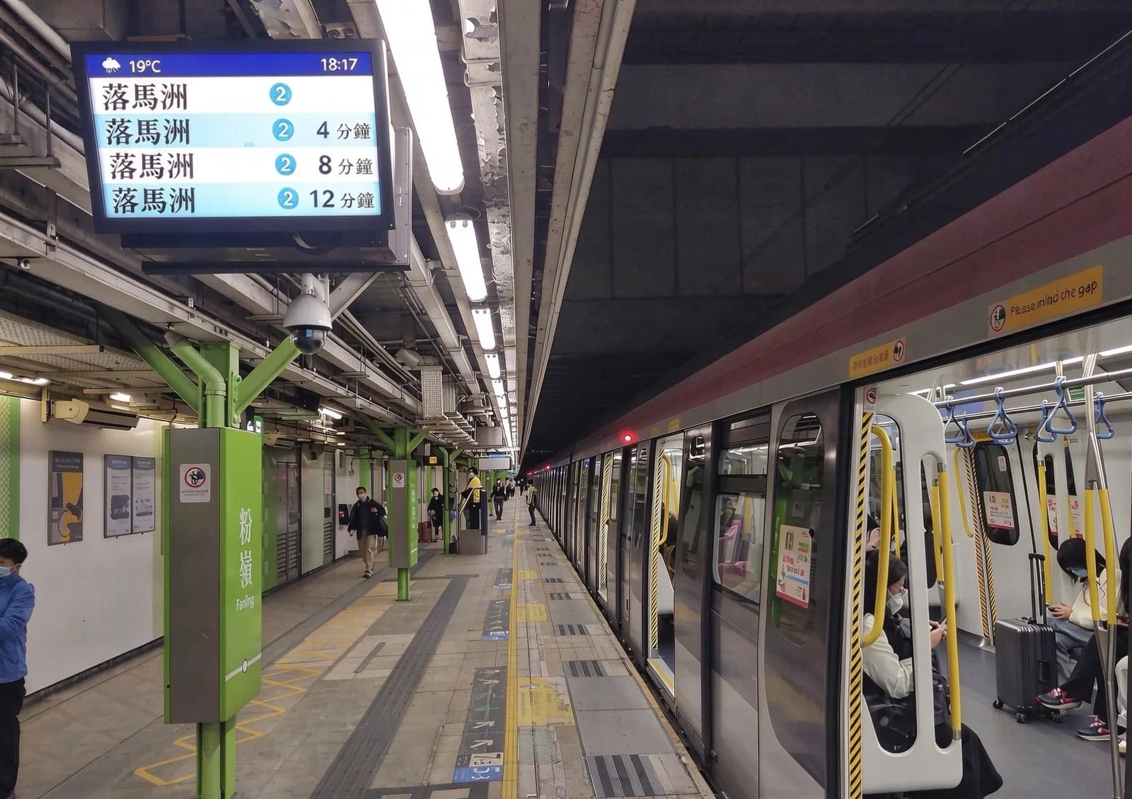 East Rail Line platform at Fanling station in Hong Kong, with a departure board listing trains to Lok Ma Chau