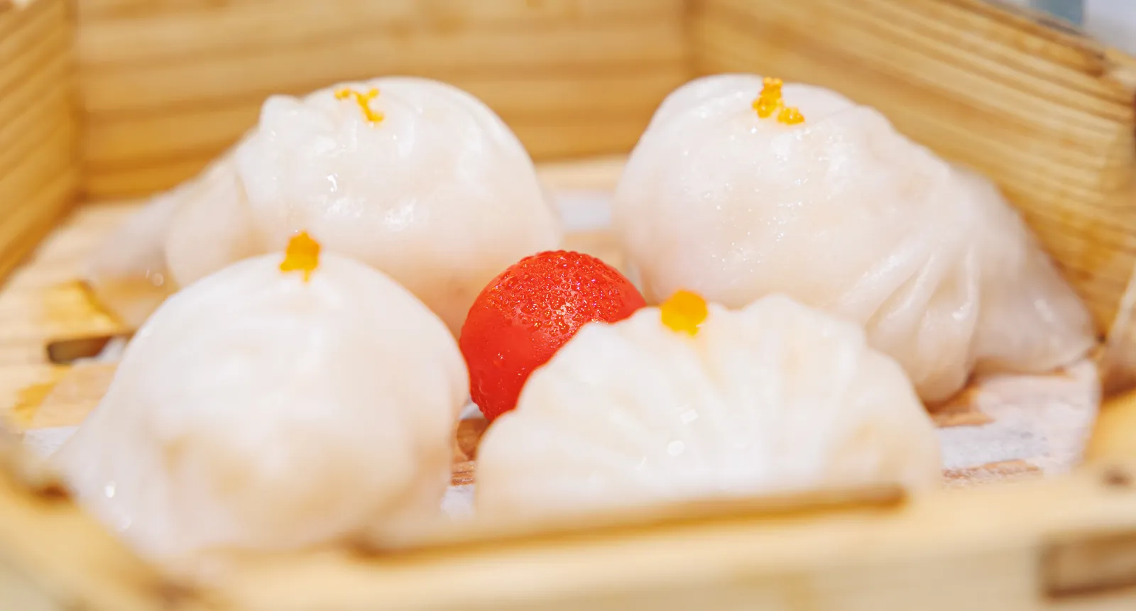 Translucent har gow shrimp dumplings in a bamboo steamer