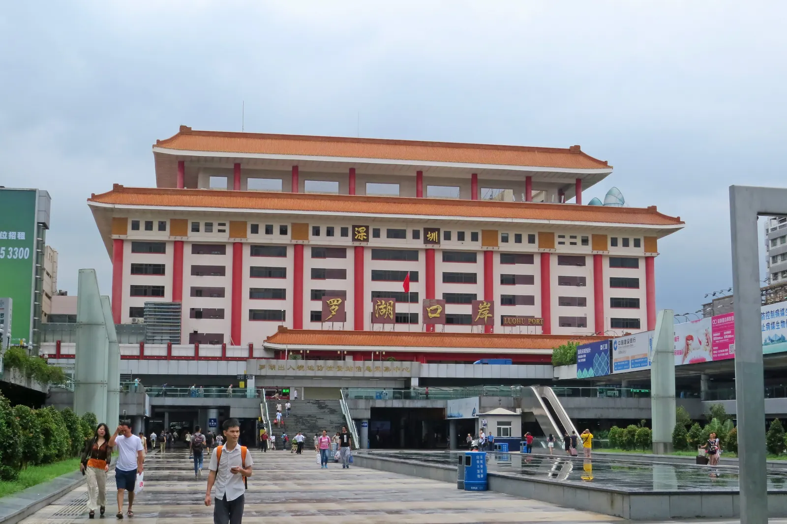 Luohu Port building with traditional roofs and travelers walking in front