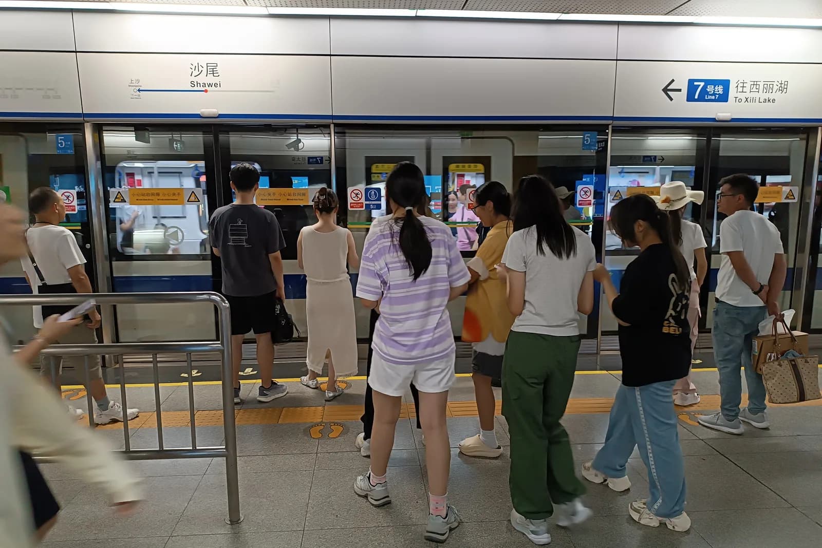 深圳地下鉄7号線・沙尾駅のホームドア前に詰めて並ぶ乗客