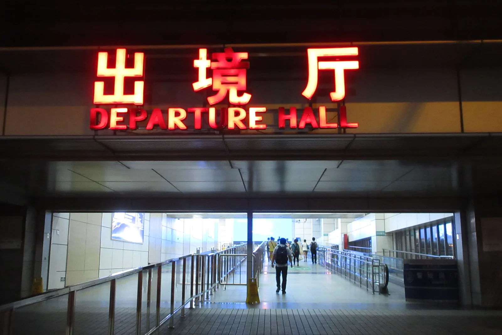 Shenzhen Bay Port Departure Hall entrance at night under its red bilingual sign