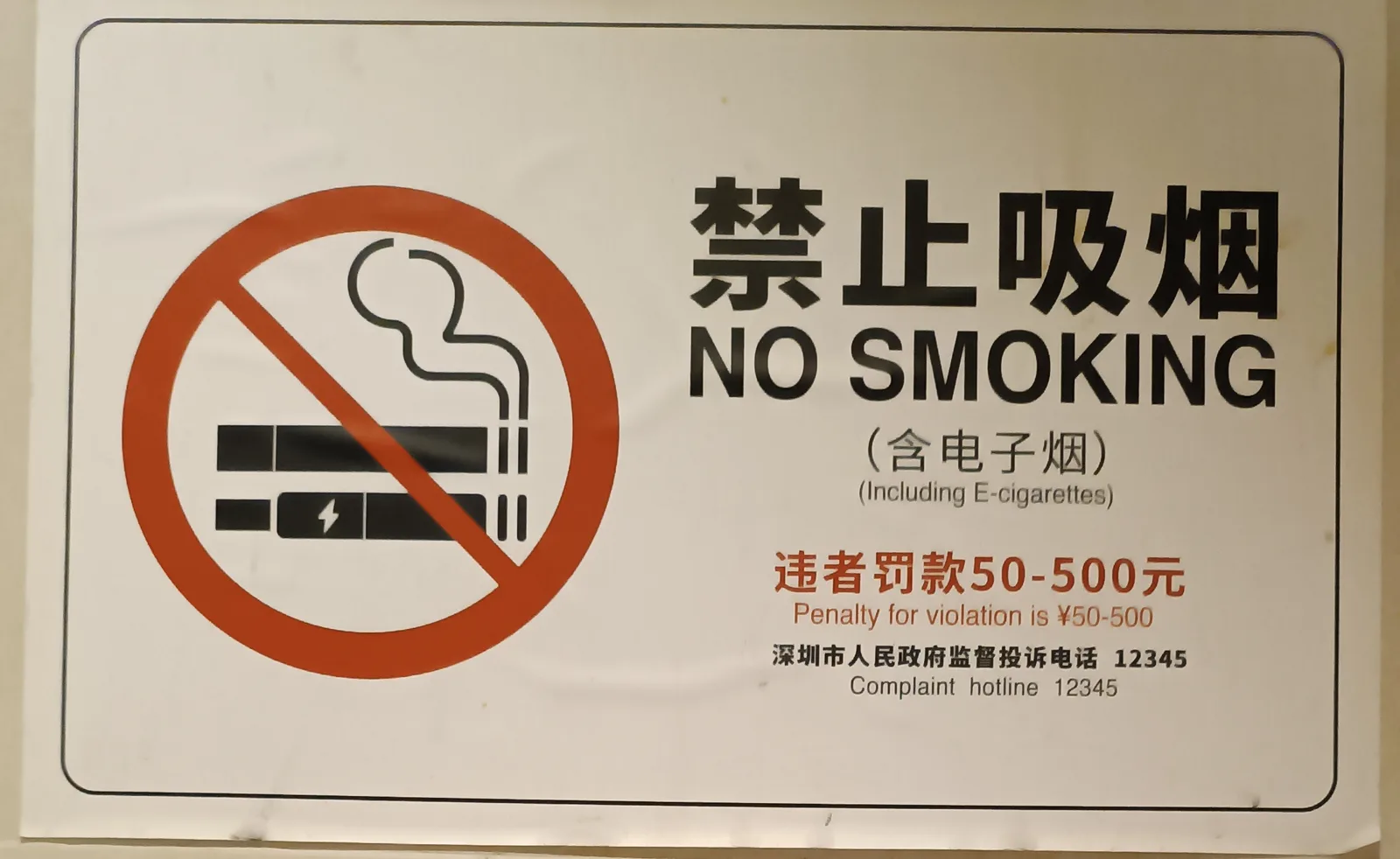 A Shenzhen no-smoking sign covering e-cigarettes, with a 50–500 yuan fine and the 12345 complaint hotline