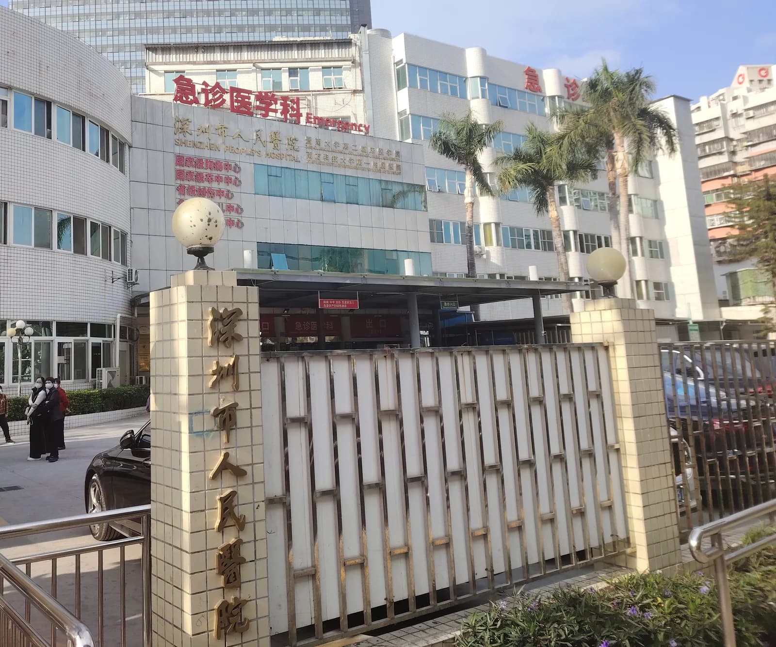 Shenzhen People's Hospital gate with the red 急诊医学科 Emergency sign above the emergency entrance