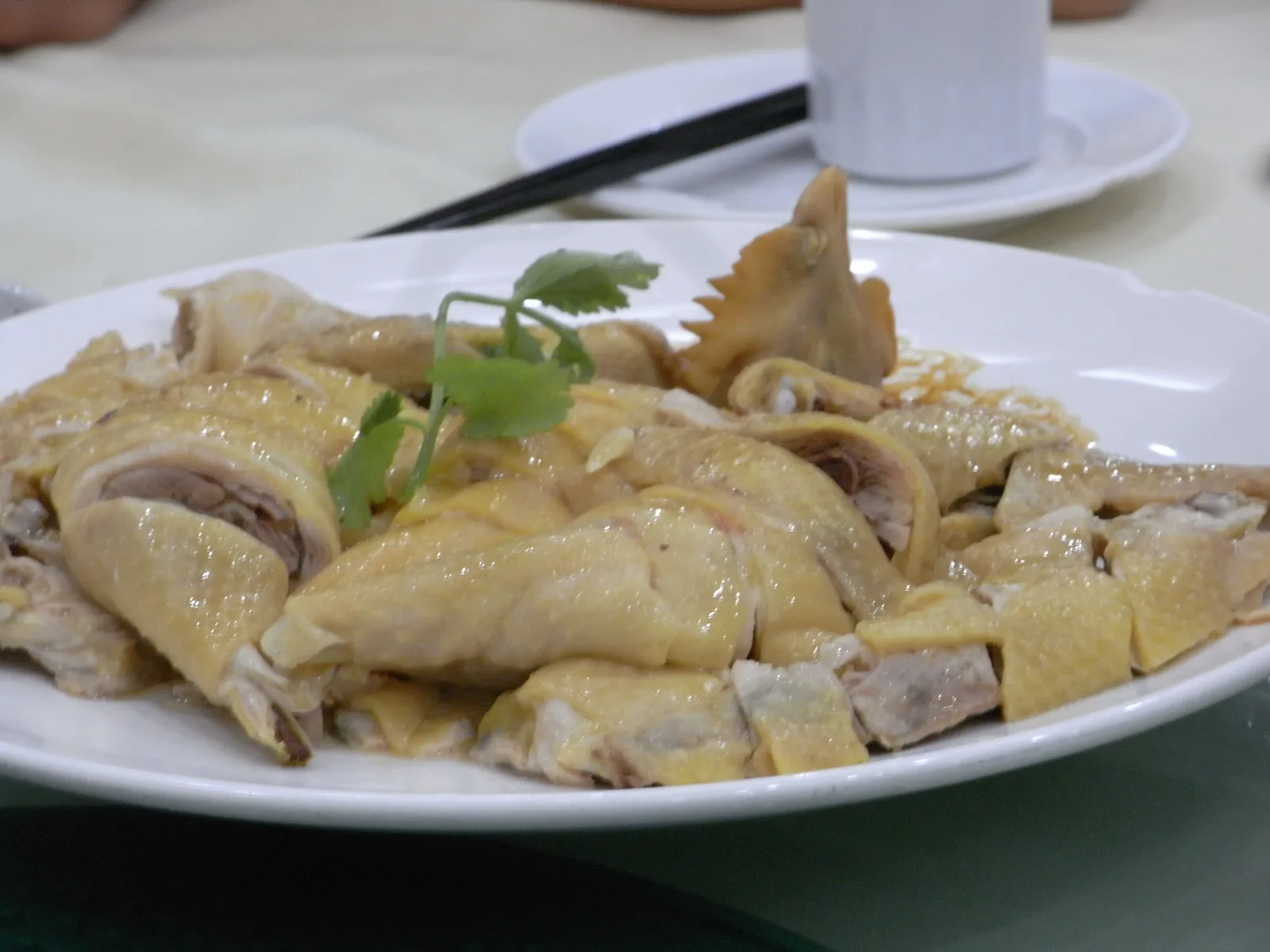 Plate of Cantonese white-cut chicken garnished with coriander at a Shenzhen restaurant