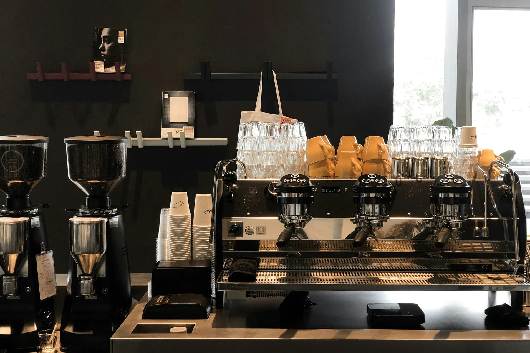 Espresso machines, grinders and cups lined up on a specialty coffee bar