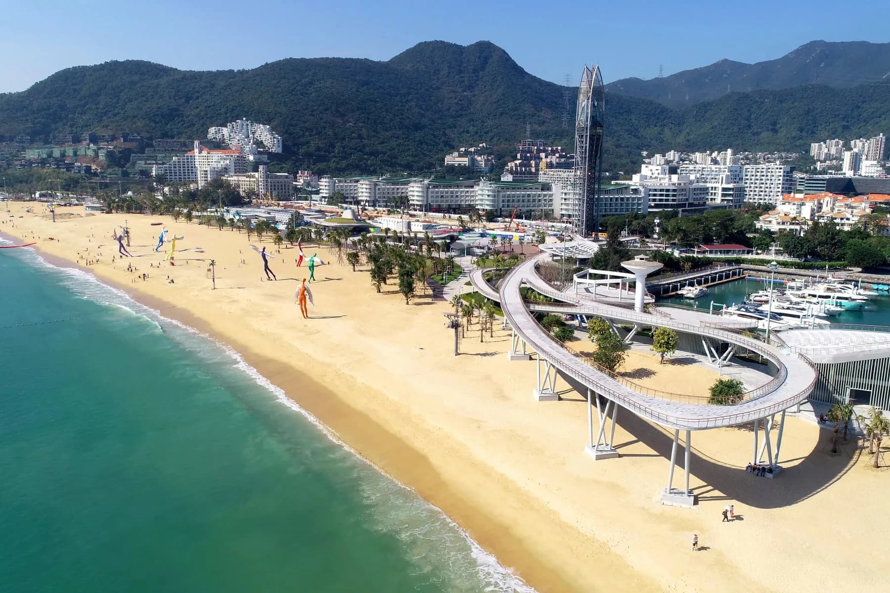 Visitors walking beside the water at Dameisha Seaside Beach Park in Shenzhen