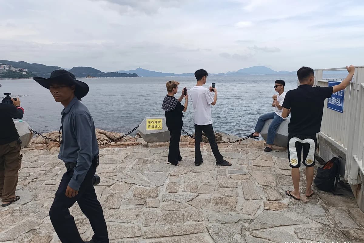 Visitors walking beside the water at Dameisha Seaside Beach Park in Shenzhen