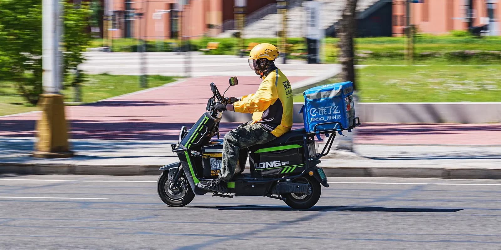 Food delivery rider on an electric scooter with an Ele.me box
