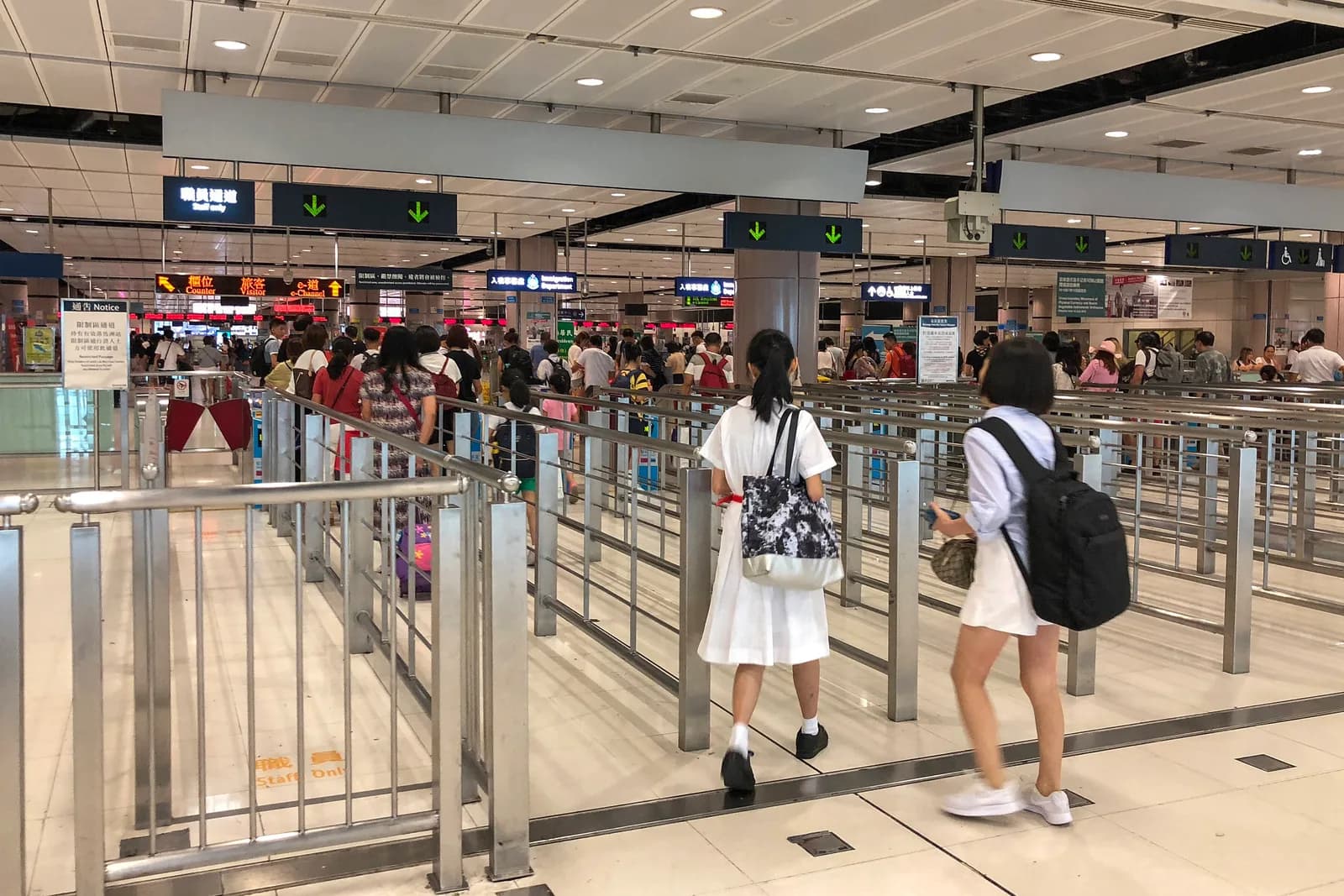 Travelers queuing at visitor counters inside the Lok Ma Chau immigration hall connecting to Futian Port