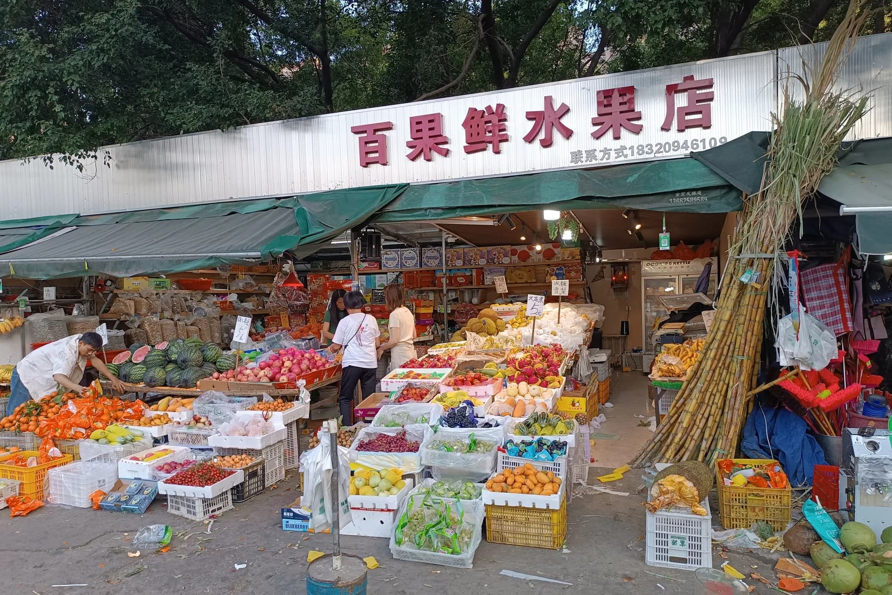 Neighborhood fruit market stall with handwritten RMB price signs in Nanshan, Shenzhen