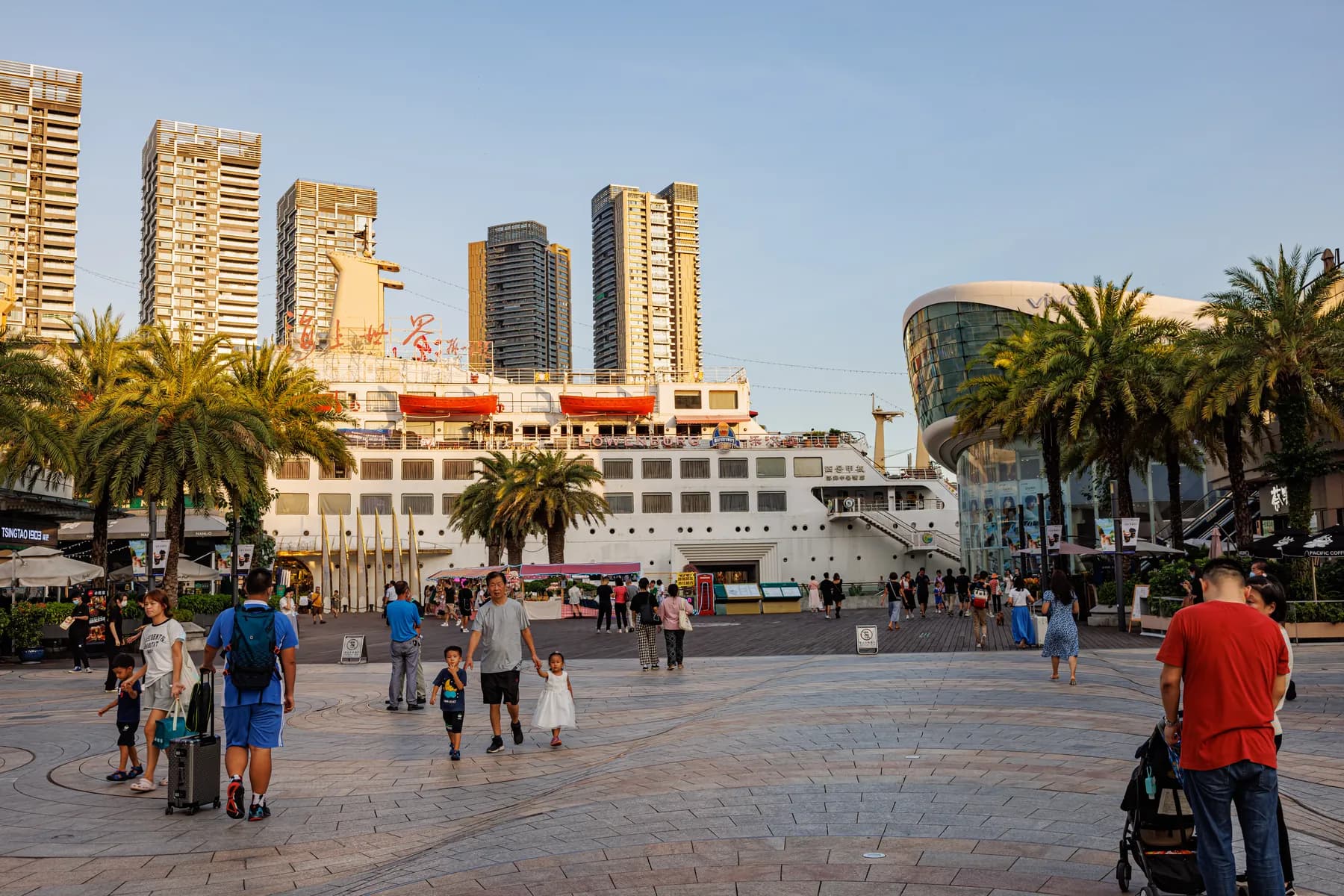 Palm-lined Sea World plaza in Shekou with the Minghua ship and evening crowds