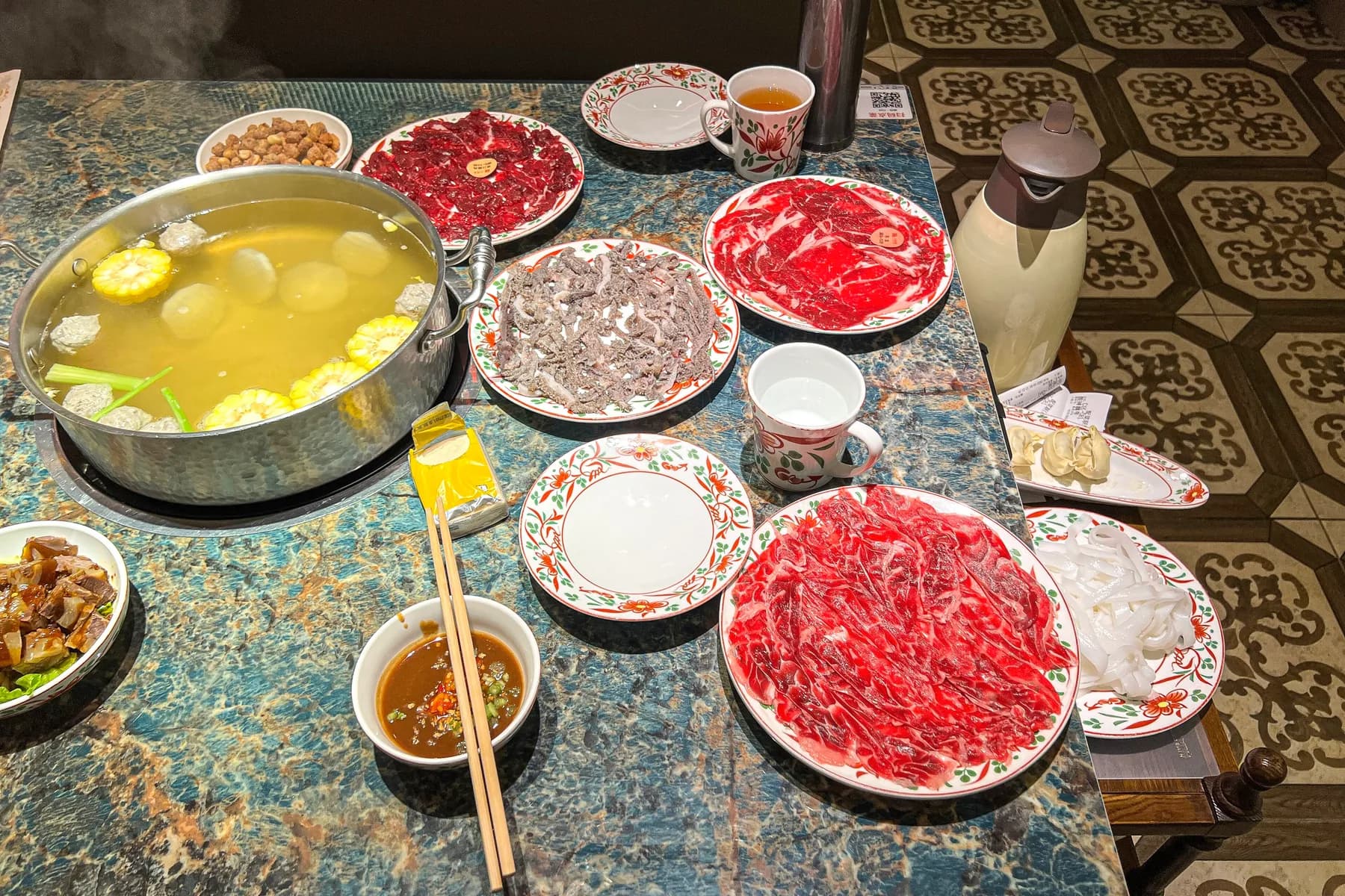 Chaoshan beef hotpot table at Baheli Haiji with clear broth pot and plates of fresh hand-sliced beef